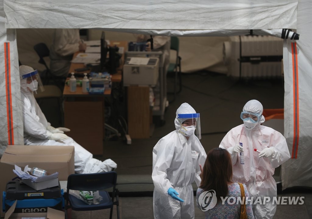 资料图片：5月18日，市民在首尔龙山区卫生站的筛查所接受新冠病毒检测。 韩联社