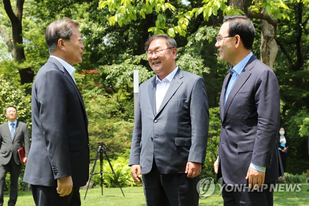 5月28日，在青瓦台，韩国总统文在寅（左）与执政党共同民主党党鞭金太年（中）、最大在野党未来统合党党鞭朱豪英交谈。 韩联社