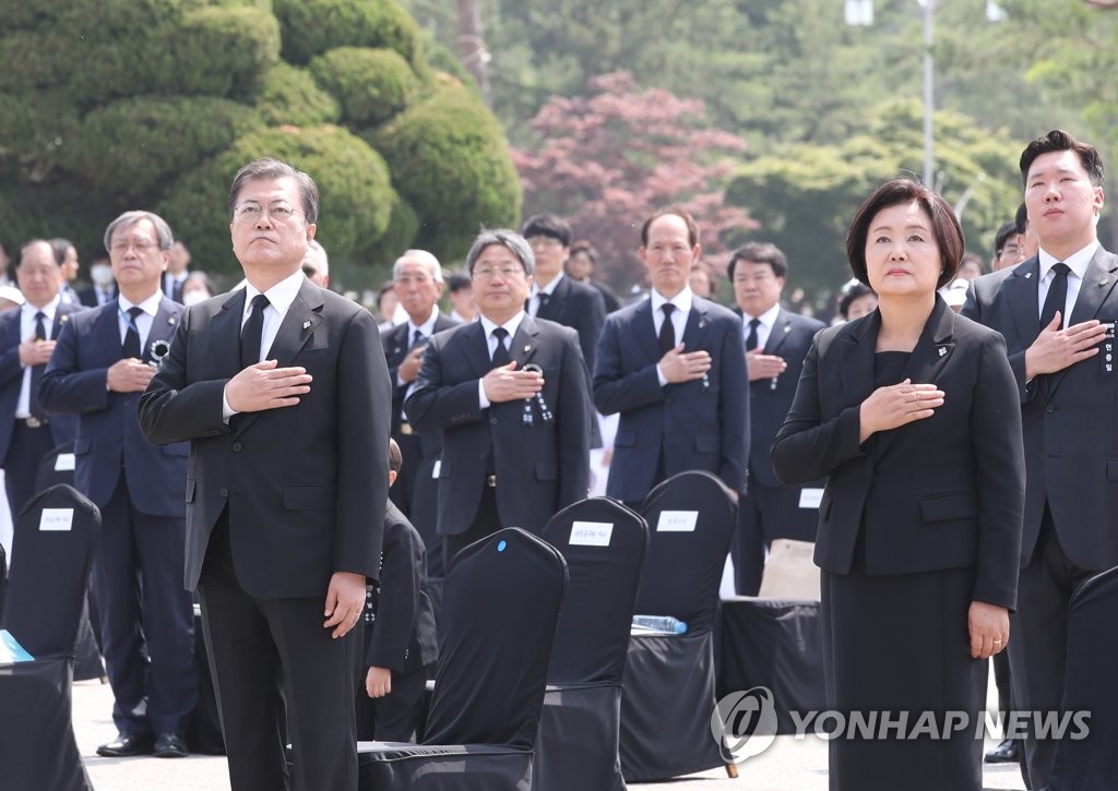 6月6日上午，文在寅（前排左）和夫人金正淑女士在第65届显忠日纪念仪式上向国旗敬礼。韩联社