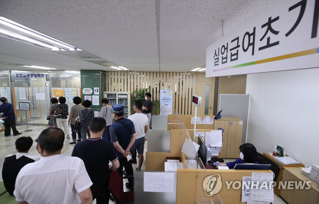 资料图片：大批待业者排队进入位于首尔中区的就业福利中心，准备听取失业津贴领取说明。 韩联社