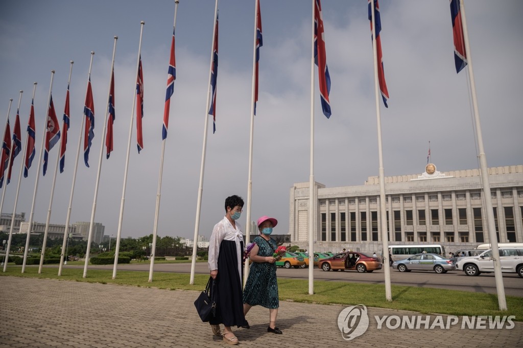 资料图片：7月8日，在平壤，2名女性戴口罩前往万寿台悼念已故领导人金日成。 韩联社/法新社（图片严禁转载复制）