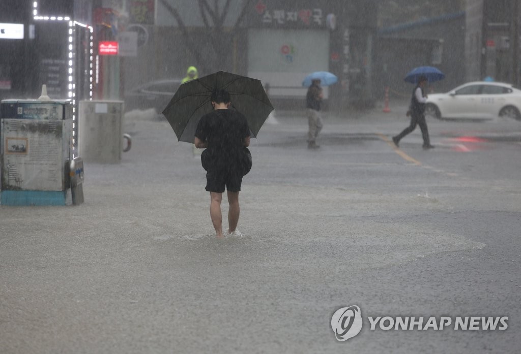 资料图片：7月10日上午，釜山市海云台区出现暴雨天气，市区部分道路被淹。当天，釜山市发布暴雨预警。 韩联社