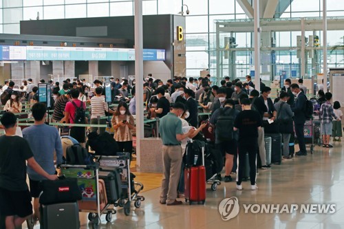 资料图片：2020年7月23日，在仁川国际机场第二航站楼出发大厅，即将飞往中国广州的企业人员等待办理登机手续。 韩联社