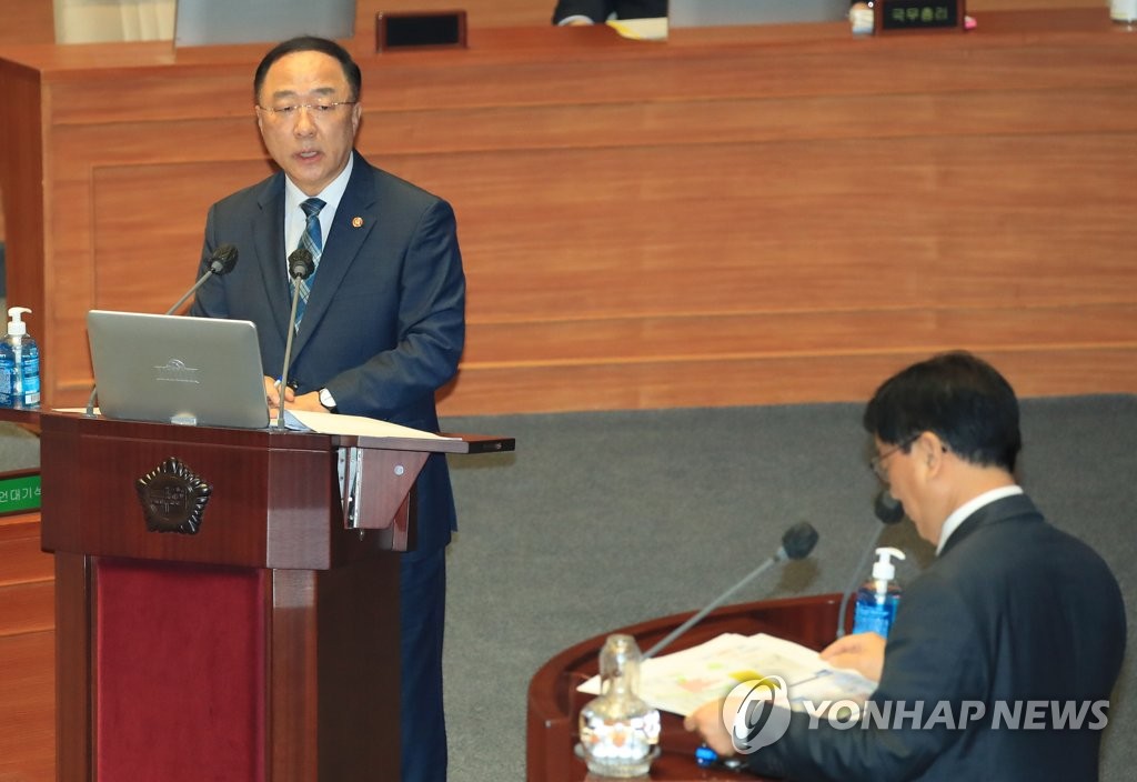 7月23日，经济副总理兼企划财政部长官洪楠基（左）在国会质询政府工作大会上回答提问。 韩联社
