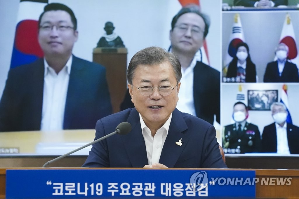 7月24日，在首尔外交部综合状况室，文在寅在旅外同胞视频座谈会上同驻印度大使申凤吉（屏幕中右）和当地韩侨亲切对话。 韩联社