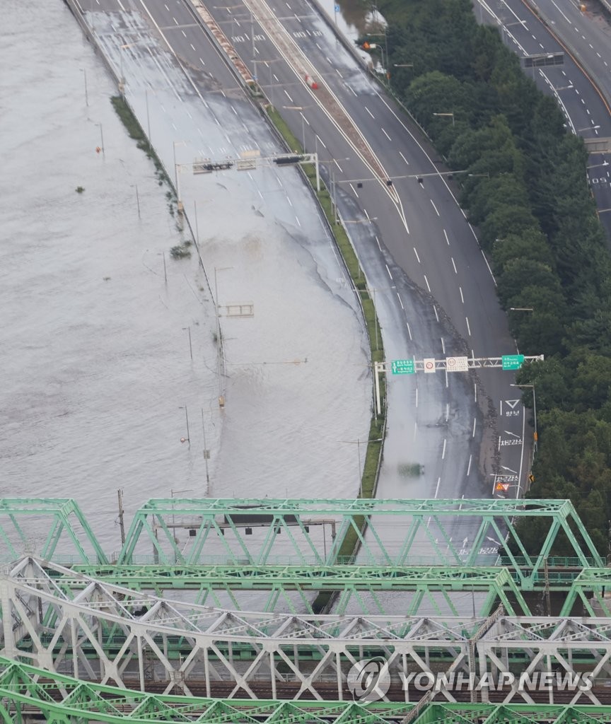 资料图片：8月6日，在首尔，汉江铁桥下的奥林匹克大道被水淹没。 韩联社