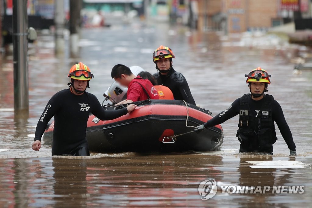 资料图片：8月8日，全罗南道求礼郡求礼邑救援队紧急疏散被困居民。 韩联社