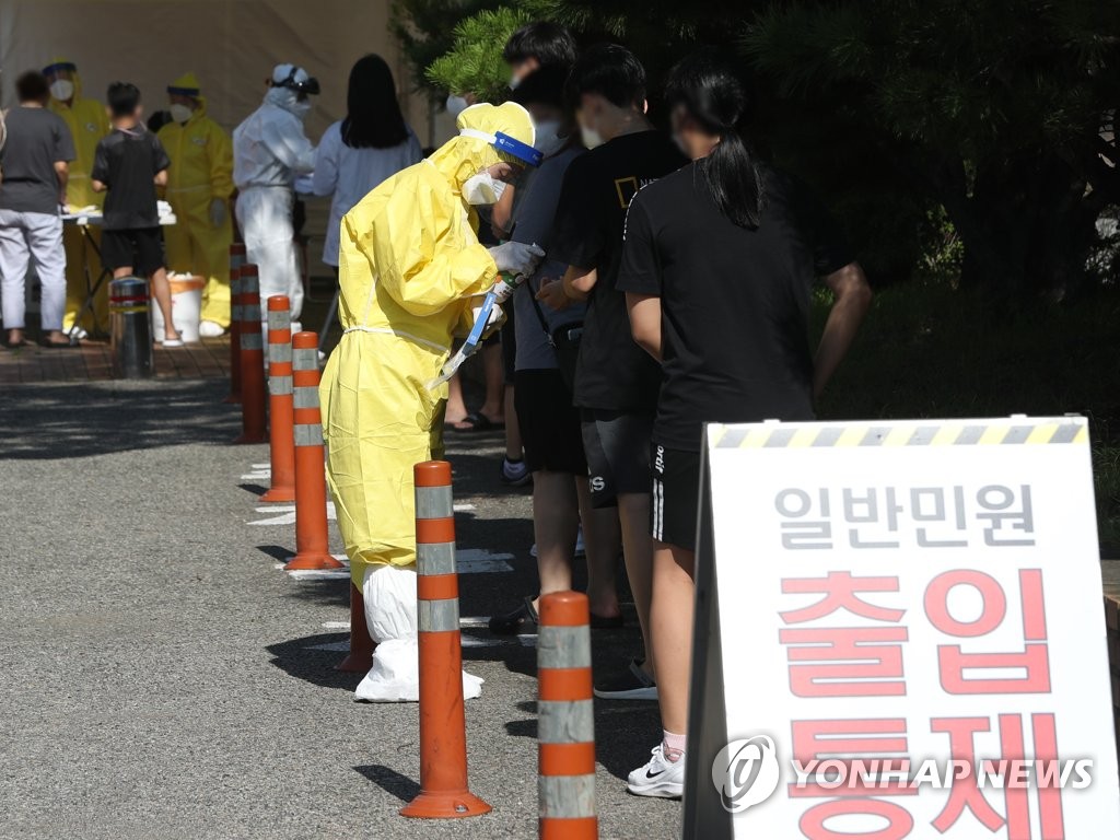 资料图片：市民们排长龙等待接受病毒检测。 韩联社
