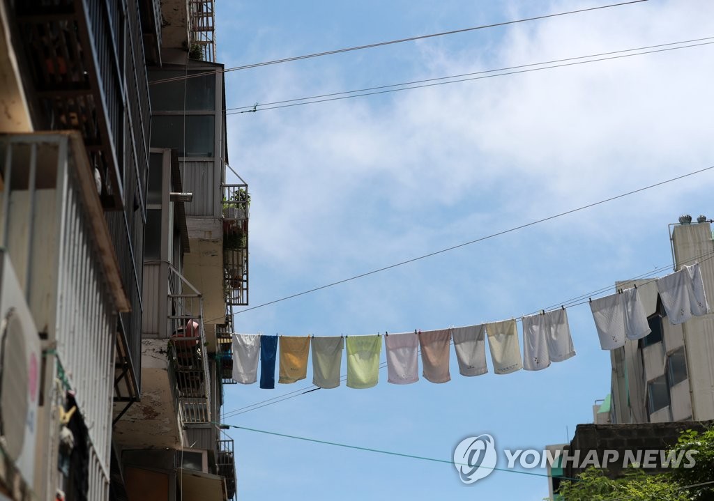 资料图片：8月14日，在釜山市某公寓，衣服被晾晒在太阳下。 韩联社