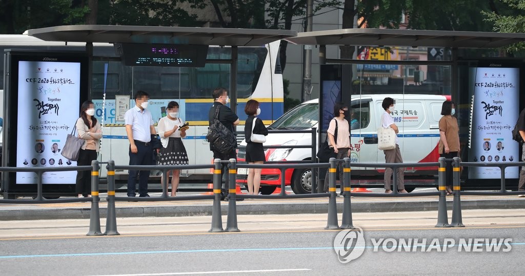 资料图片：8月25日，在首尔，市民们戴着口罩等待公交车。 韩联社