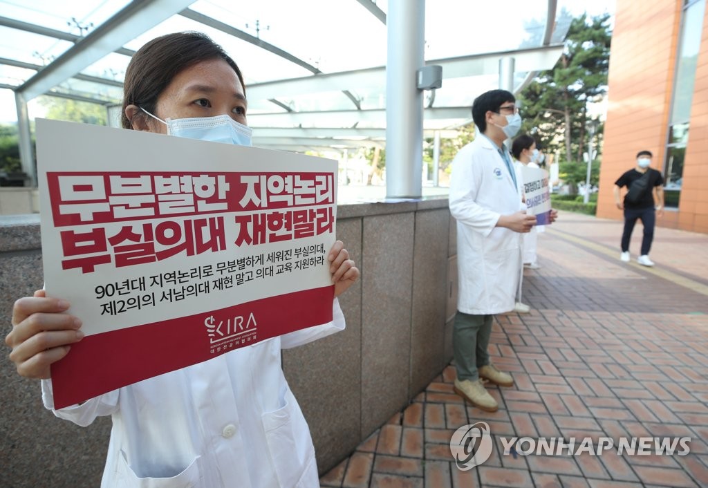 8月26日上午，在首尔圣母医院，实习医生举标牌示威抗议政府扩招政策。 韩联社