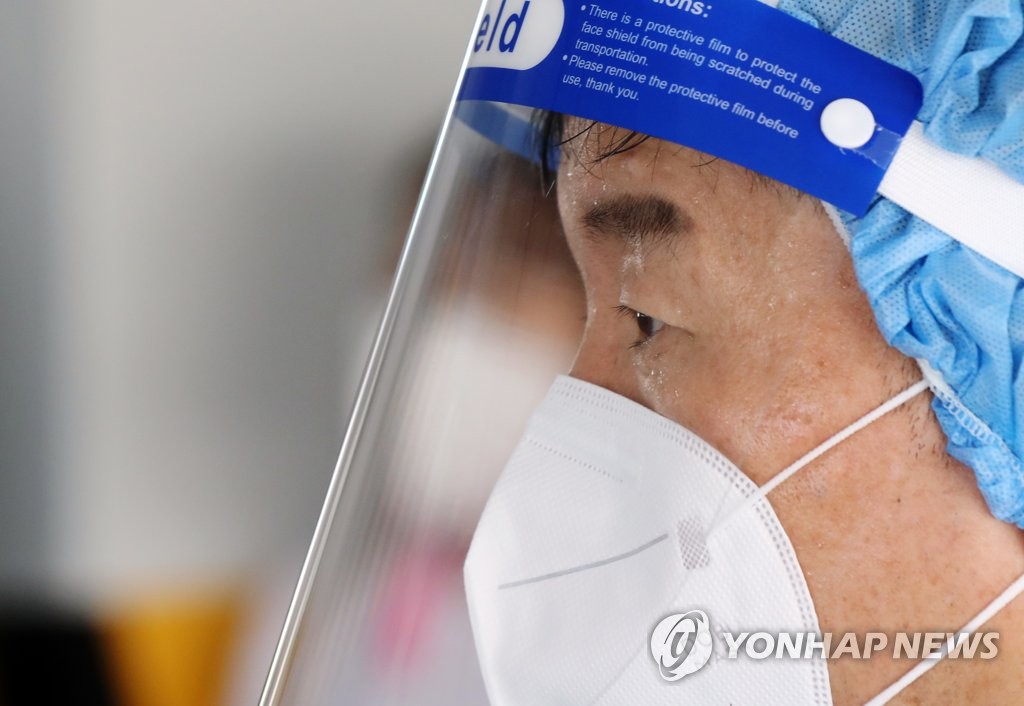 资料图片：医务人员在高温天坚守一线。 韩联社