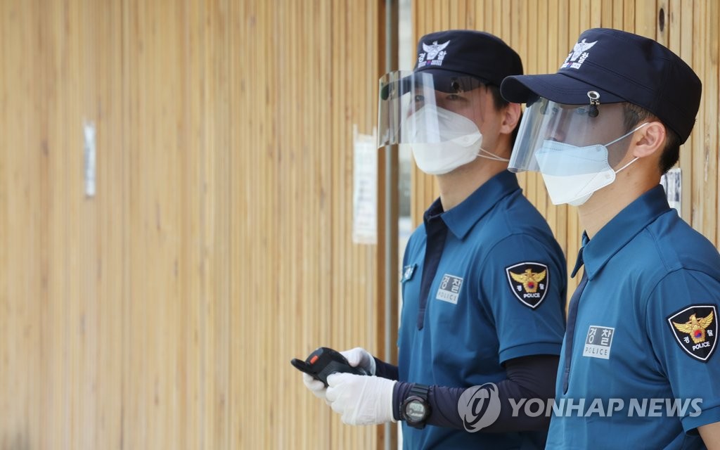 资料图片：8月28日，在首尔市光化门广场，警察们戴透明面罩、口罩和手套值勤。 韩联社