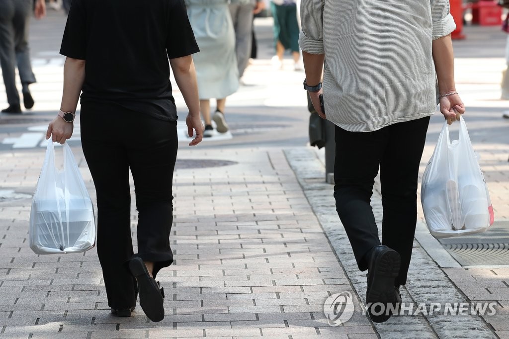 资料图片：9月4日，韩国政府决定将针对首都圈实施的加强版防疫措施延长一周至13日。图为上班族将午饭打包带回公司。 韩联社