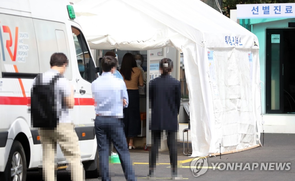资料图片：市民等待接受新冠病毒检测。 韩联社