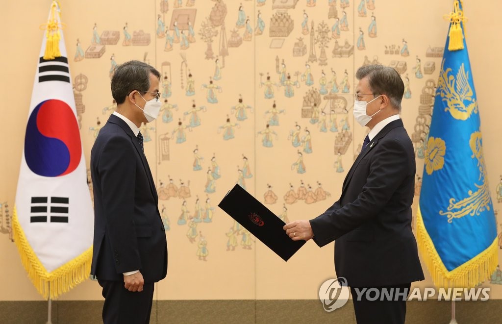 9月18日，在青瓦台，韩国总统文在寅（右）向大法官李兴九颁发任命书。 韩联社