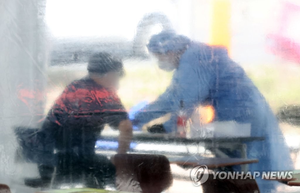 资料图片：医生进行新冠病毒检测采样。 韩联社TV供图（图片严禁转载复制）