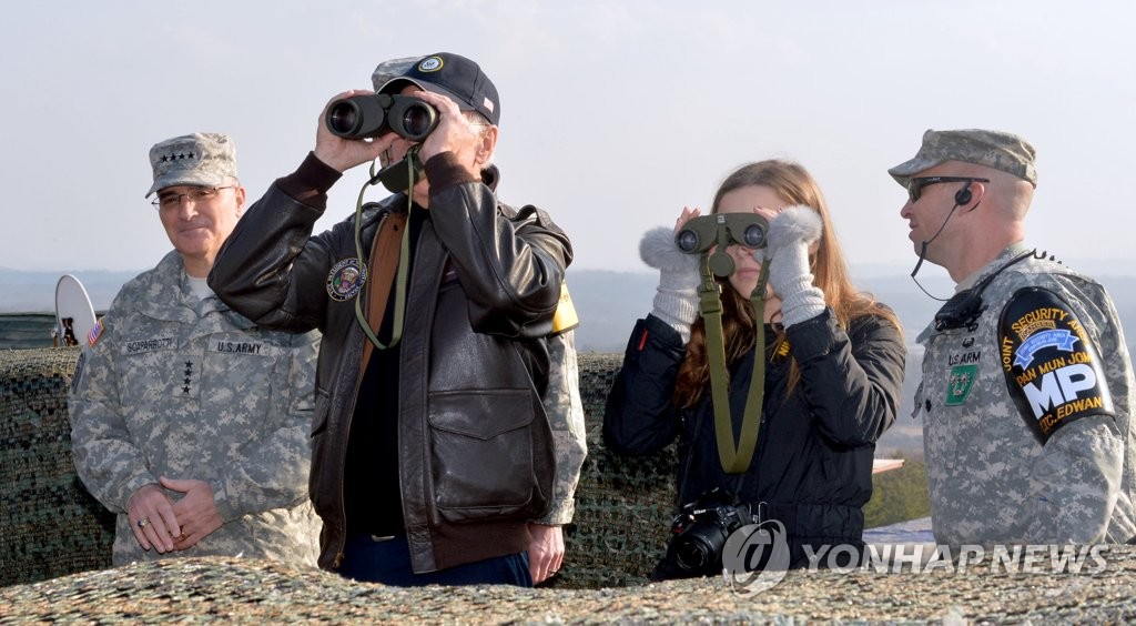 资料图片：2013年12月7日，在板门店，拜登和孙女芬尼根手持双筒望远镜遥望朝鲜。 韩联社