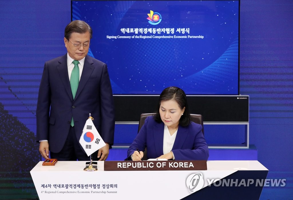 11月15日，总统文在寅（左）和产业通商资源部通商交涉本部长俞明希以视频形式出席《区域全面经济伙伴关系协定》签署仪式。 韩联社