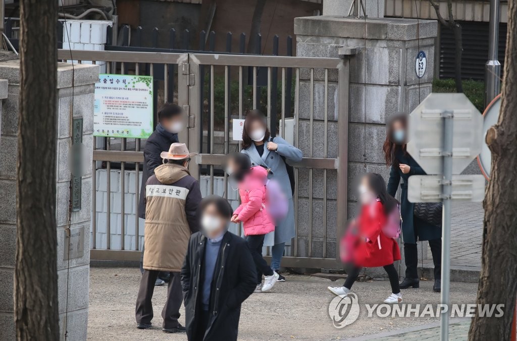 资料图片：小学生们到校上课。 韩联社