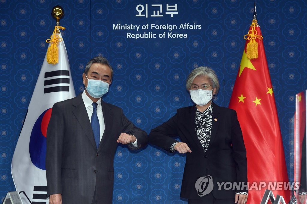 11月26日，在首尔外交部大楼，韩国外交部长官康京和（右）和到访的中国外交部长王毅在会谈开始前用肘击替代握手致意，并合影留念。 韩联社/联合摄影团