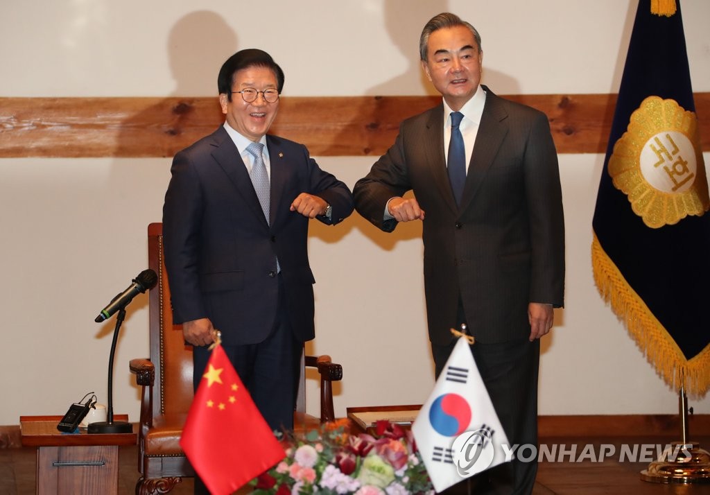 11月27日，在国会，韩国国会议长朴炳锡（左）和中国外交部长王毅在举行会谈前碰肘问候。 韩联社
