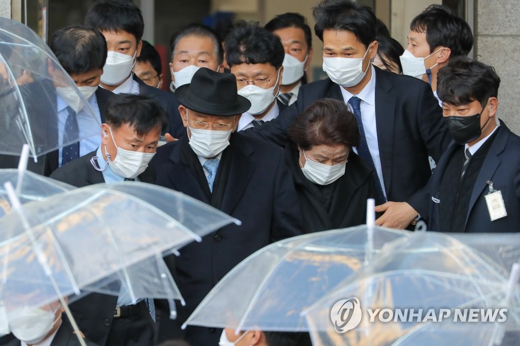 资料图片：2020年11月30日，在光州地方法院，全斗焕（居中，戴帽子）在一审宣判结束后走出法庭。 韩联社