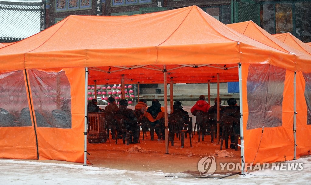 材料图片：12月13日，在首尔市钟路区的曹溪寺，释教信徒们
相互连结距离
祷告。 韩联社