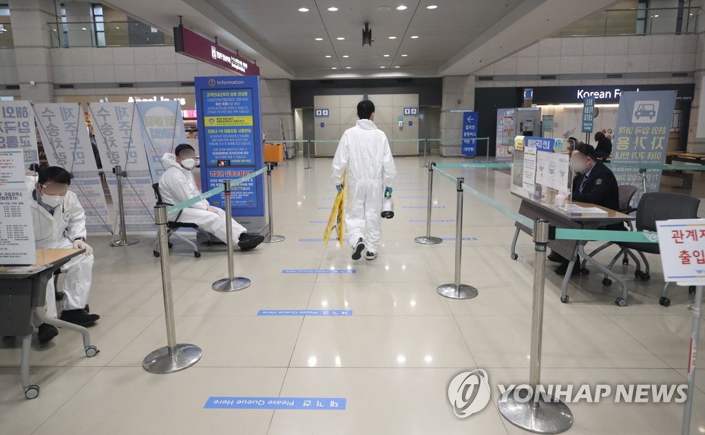 1月1日，在位于永宗岛的仁川国际机场1号航站楼入境处，工作人员正在进行消毒。 韩联社