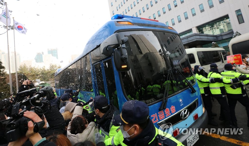 1月13日，在首尔南部地方法院，愤怒的市民围堵郑仁养母乘坐的护送车辆。 韩联社