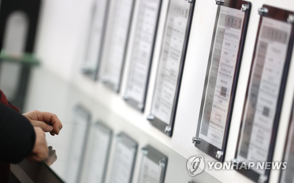 资料图片：1月13日，市民在首尔西部就业福利中心查看招聘启事。 韩联社
