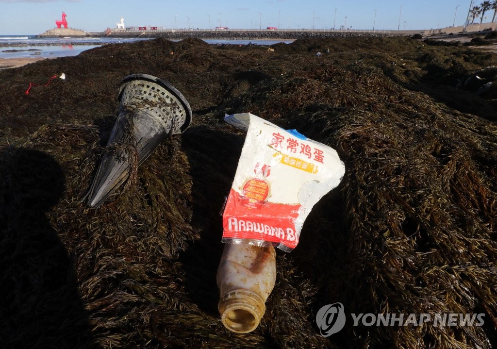 1月19日,在济州道济州市梨湖海水浴场,
事情
职员在断根自华流入的铜藻和陆地渣滓。 韩联社