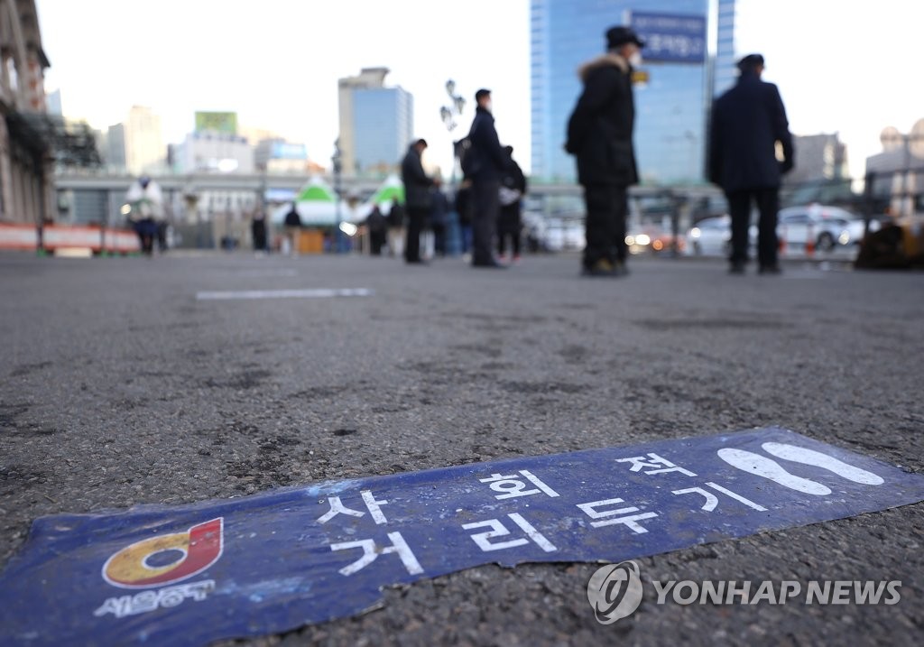 资料图片：1月27日，在设于首尔火车站广场的筛查诊所，市民们排队等待接受病毒检测。 韩联社