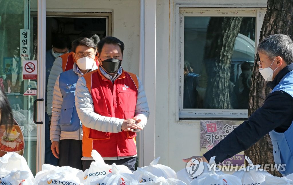 资料图片：1月29日，SK集团会长崔泰源（左）在庆尚北道浦项市南区一餐厅参加为困难人群制作便当的公益活动。 韩联社