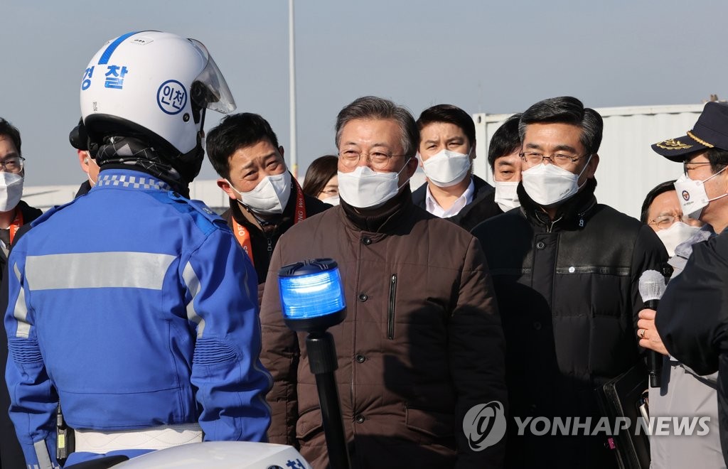 2月3日，在仁川国际机场大韩航空货物航站楼，文在寅（居中）勉励新冠疫苗运输应急演练参演人员。 韩联社