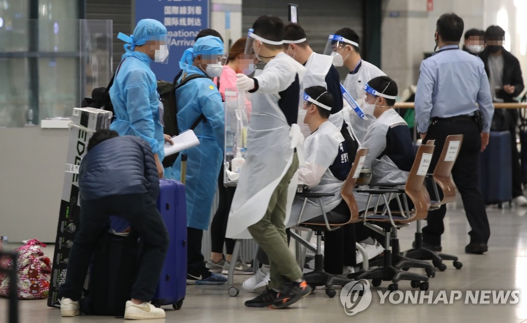 资料图片：2月5日，在仁川国际机场，陆军检疫支援团为身穿防护服的入境人员提供指引。 韩联社