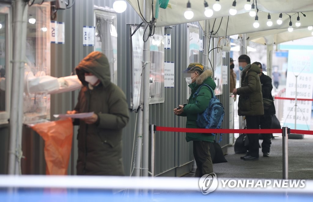 资料图片：2月6日，在设于首尔火车站广场的临时筛查诊所，市民等待接受病毒检测。 韩联社