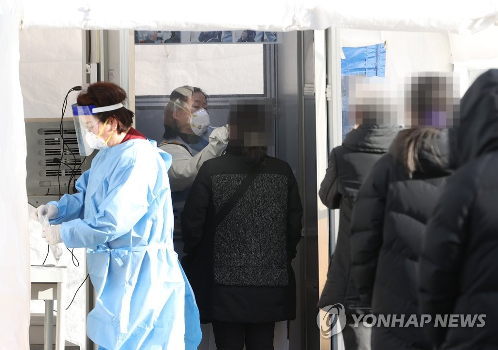 资料图片：2月8日，在设于首尔中区国立中央医疗院的筛查诊所，医务人员采集咽拭子标本。韩联社