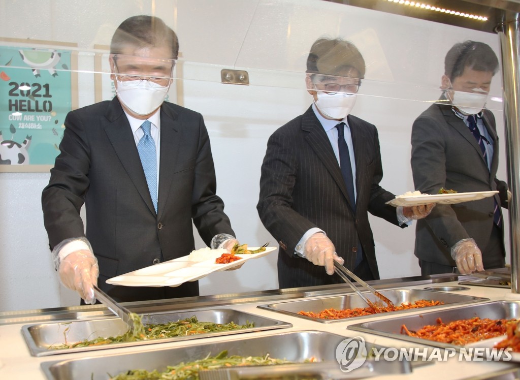 2月9日，在韩国外交部办公楼单位食堂，外交部长官郑义溶（左一）排队取餐。 韩联社