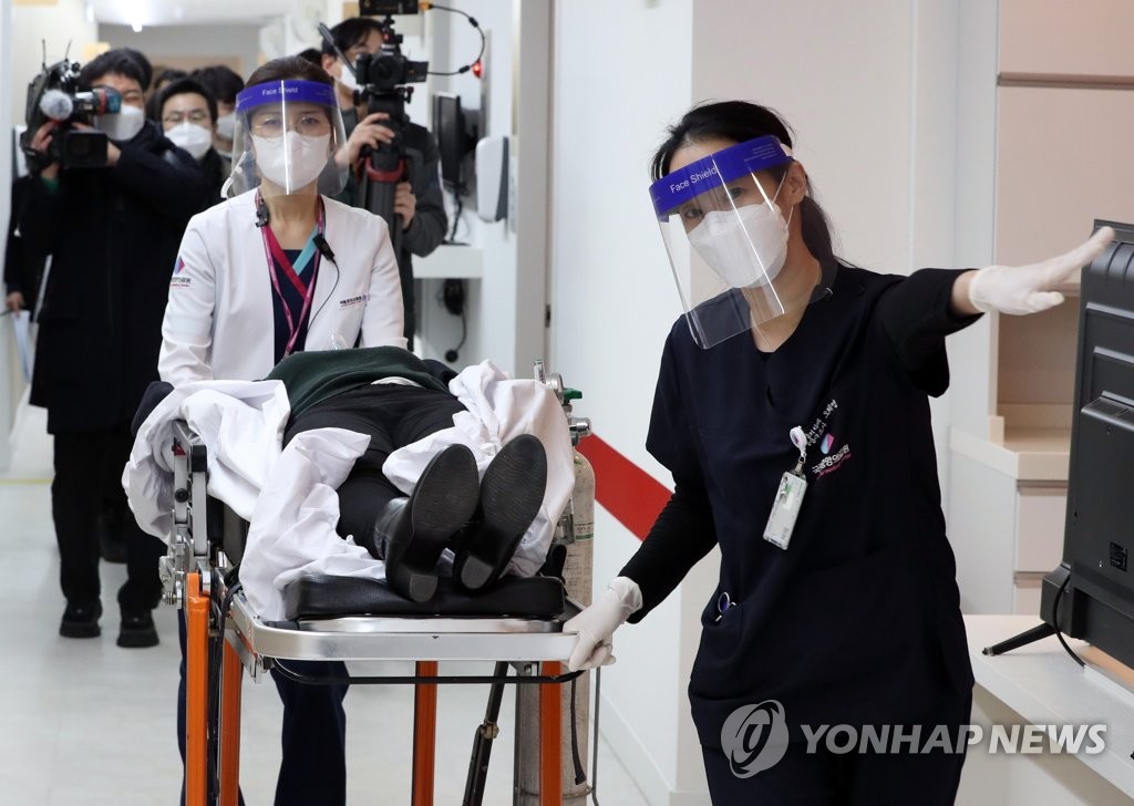 2月9日，在位于首尔中区的国立中央医疗院中央预防接种中心，医务人员在新冠疫苗接种模拟演练中将接种后出现异常反应的人员移送至急诊室。 韩联社/联合摄影团
