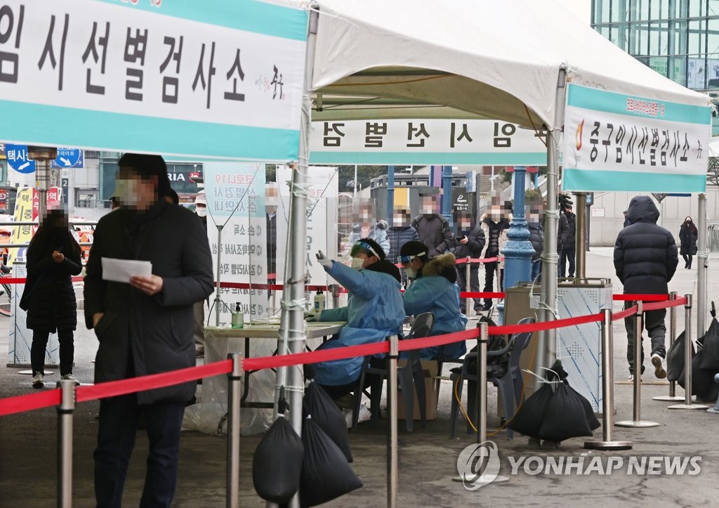 资料图片：2月10日，在设于首尔火车站广场的临时筛查诊所，市民等待接受病毒检测。 韩联社