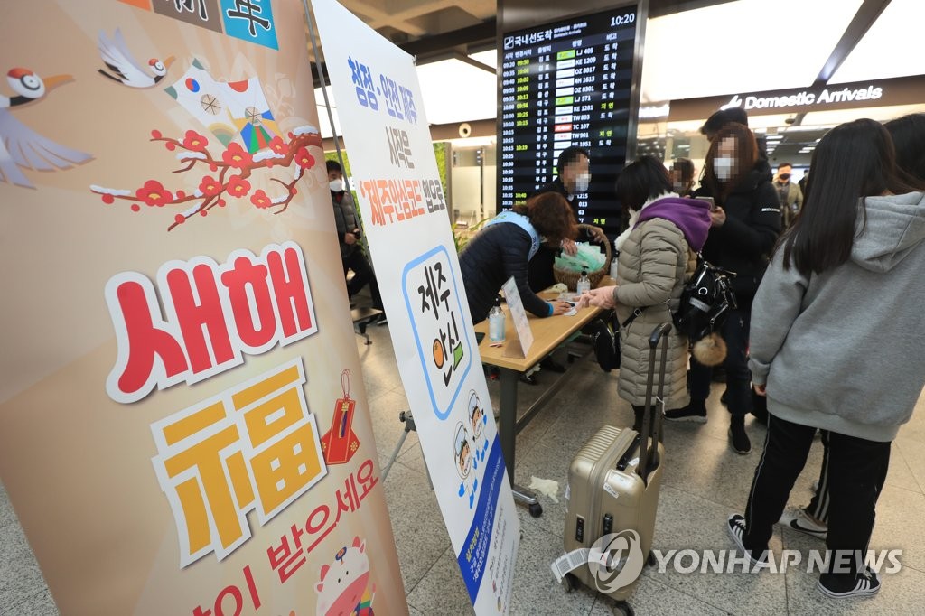 资料图片：2月11日，在济州机场，不少乘客排队领口罩。 韩联社