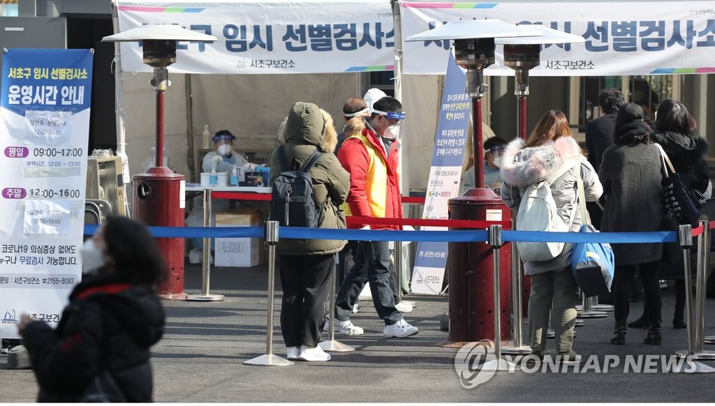 资料图片：2月13日，在首尔高速巴士客运站前设置的临时筛查诊所，市民们排队等待病毒检测。 韩联社