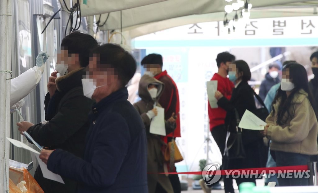 资料图片：市民们排队待检。 韩联社