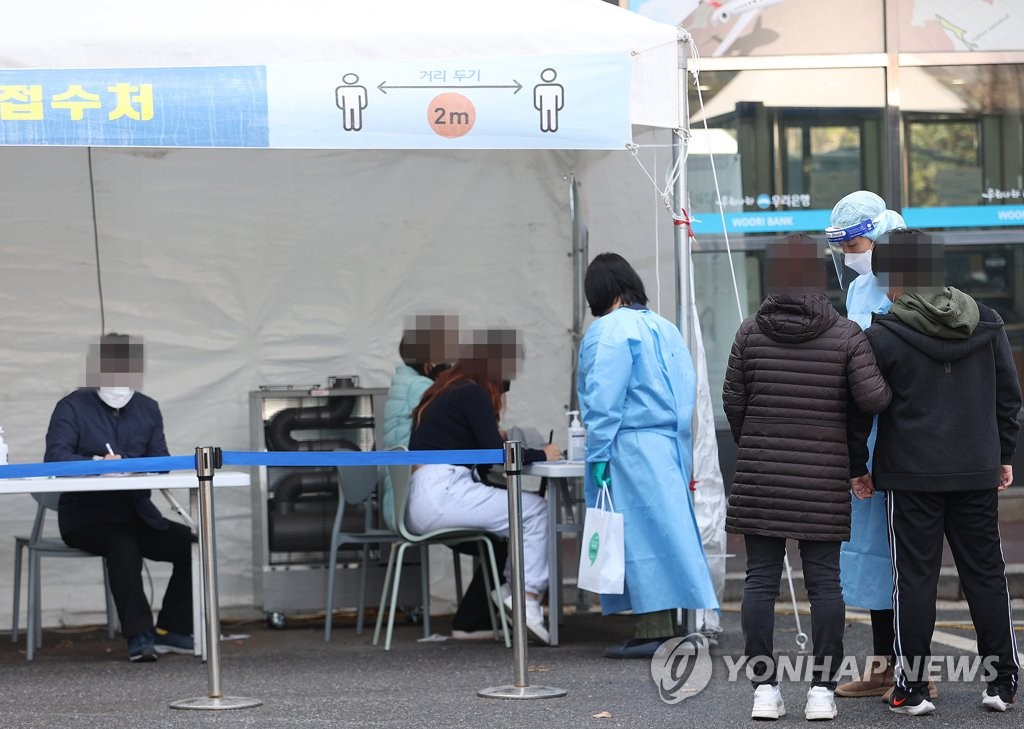 资料图片：市民们排队等候接受病毒检测。 韩联社