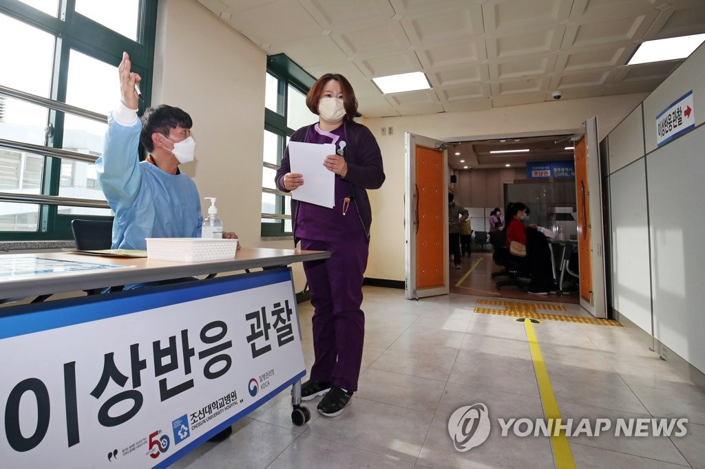 资料图片：3月3日，在光州市朝鲜大学新冠疫苗接种点，医务人员指引辉瑞疫苗接种者前往异常反应观察室。 韩联社/光州、全罗南道摄影记者团