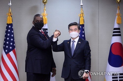 3月17日，在首尔龙山区国防部大楼，韩国国防部长官徐旭（右）与美国国防部长劳埃德·奥斯汀互相碰臂示意。 韩联社/联合摄影记者团