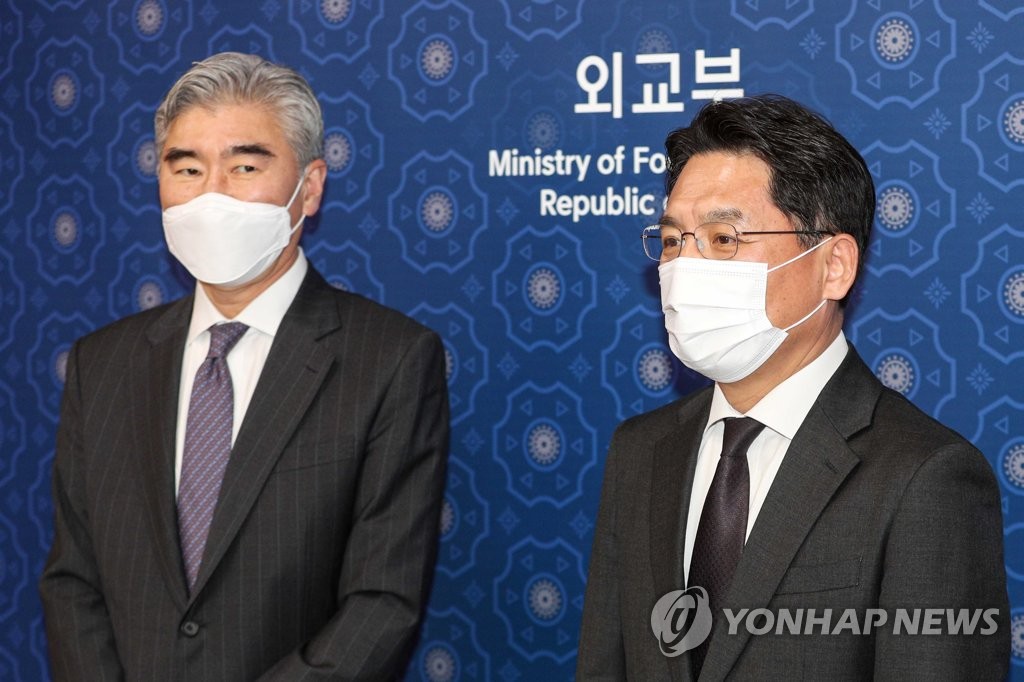 资料图片：2021年3月18日，在位于首尔市的外交部办公大楼，外交部韩半岛和平交涉本部长鲁圭悳（右）与美国对朝特别代表星·金合影留念。 韩联社