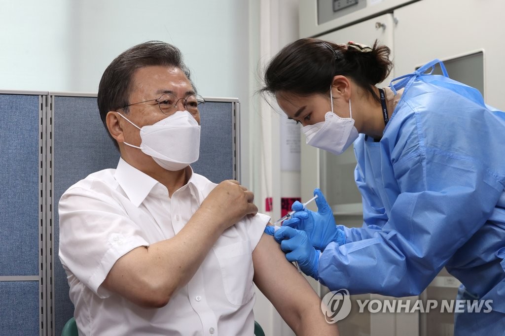 资料图片：3月23日，总统文在寅（左）在首尔市钟路区卫生站接种阿斯利康新冠疫苗。 韩联社