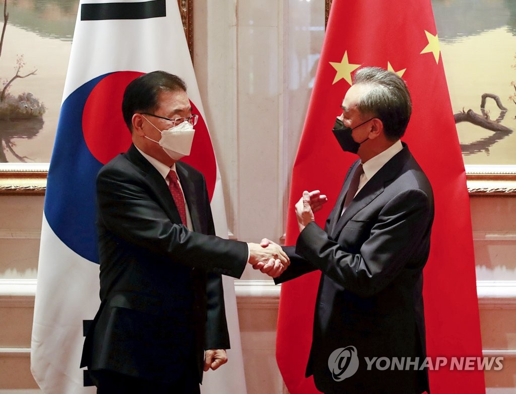 资料图片：4月3日，在中国厦门，韩国外交部长官郑义溶（左）与中国国务委员兼外交部长王毅握手致意。 韩联社